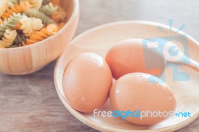 Fresh Eggs On Wooden Plate With Fusili Stock Photo