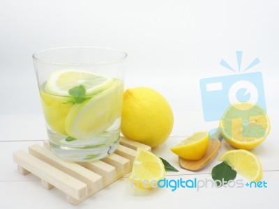 Fresh Lemon In Water And Lemon Slice On White Wood Background Stock Photo