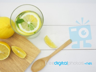 Fresh Lemon In Water And Lemon Slice On White Wood Background Stock Photo