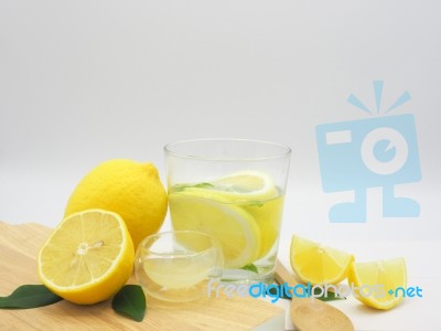 Fresh Lemon In Water, Lemonade And Lemon Slice On White Wood Bac… Stock Photo