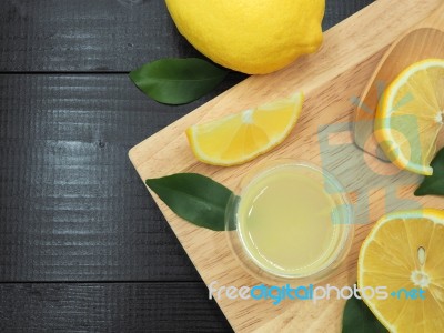 Fresh Lemon Juice In Small Bowl And Lemon Slice On Dark Wood Bac… Stock Photo