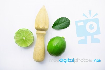 Fresh Limes And Wooden Juicer On White Background. Top View Stock Photo