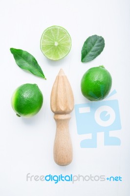 Fresh Limes And Wooden Juicer On White Background. Top View With… Stock Photo