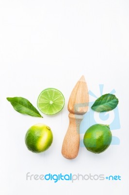 Fresh Limes And Wooden Juicer On White Background. Top View With… Stock Photo