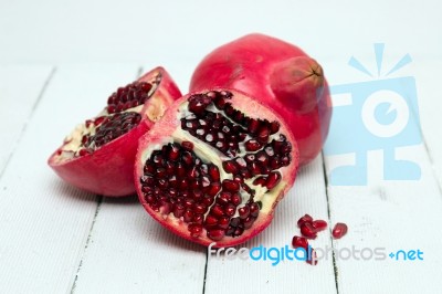 Fresh Pomegranate Fruits Isolated On A White Wooden Background Stock Photo