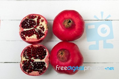 Fresh Pomegranate Fruits Isolated On A White Wooden Background Stock Photo