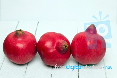 Fresh Pomegranate Fruits Isolated On A White Wooden Background Stock Photo