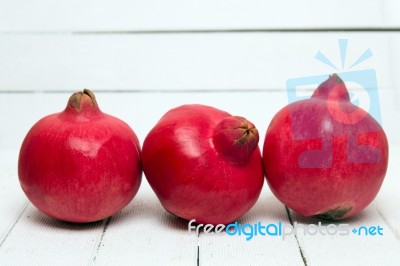 Fresh Pomegranate Fruits Isolated On A White Wooden Background Stock Photo