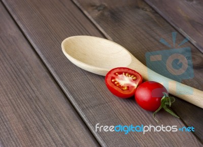 Fresh Tomatoes And Spoon On The Dark Wooden Table Stock Photo