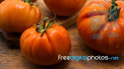 Freshly Picked Tomatoes, Place On Wooden Chopping Board And Table Stock Photo