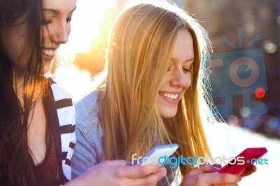 Friends Chatting With Their Smartphones Stock Photo