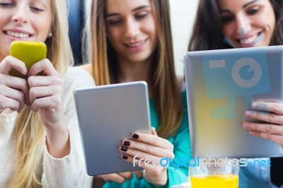 Friends Surfing The Net With Smartphones And Digital Tablets Stock Photo