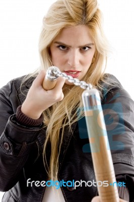 Front View Of Aggressive Female Holding Nunchaku Stock Photo