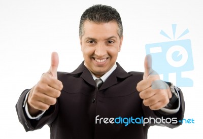 Front View Of Smiling Boss Showing Thumb Up With Both Hands Stock Photo