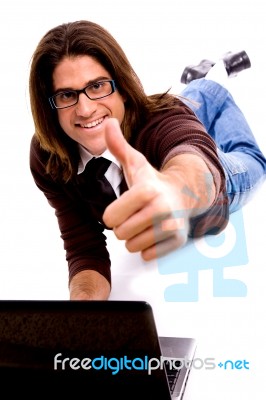 Front View Of Smiling Laying Male With Thumbs Up Stock Photo