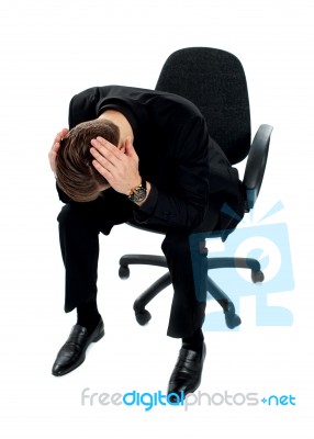 Frustrated Man Sitting On Chair Stock Photo