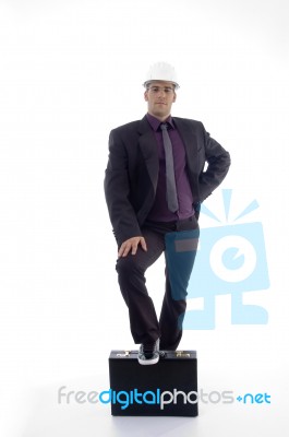 Full Body Pose Of Architect With One Leg On Briefcase Stock Photo