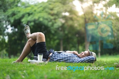 Full Length Happy Smiling Man Lying And Relaxing In Park Stock Photo