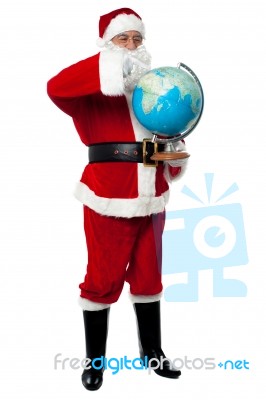 Full Length Portrait Of Santa Holding Globe Stock Photo