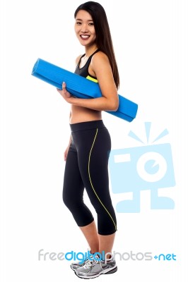 Full Length Portrait Of Slim Girl Holding Blue Mat Stock Photo