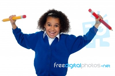 Fun Loving Elementary Girl Dancing With Pencils In Both Her Hands Stock Photo