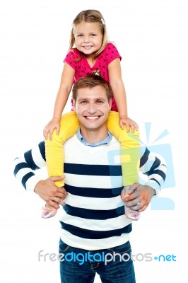 Fun Loving Kid Sitting On Her Father's Shoulders Stock Photo