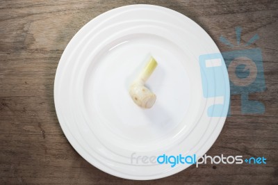 Galangal In Ceramic Dish On Wood Background Stock Photo