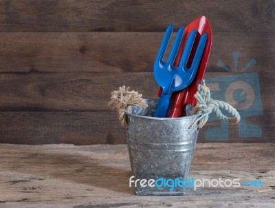 Galvanized Can With Trowel And Shovel On Grunge Wood Background Stock Photo