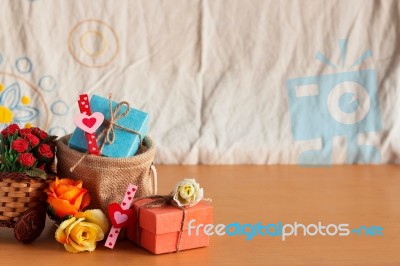 Gift And Baskets Of Roses On Wooden Stock Photo