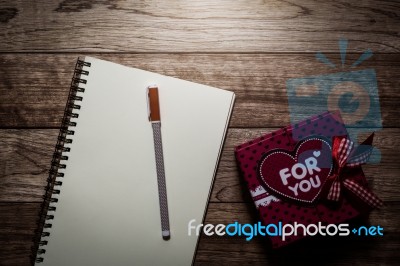 Gift Box, Notebook And Pen On Wooden Plank Stock Photo