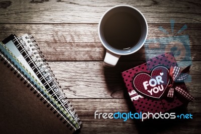 Gift Box, Notebooks And Coffee On Wooden Plank Stock Photo