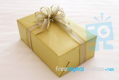 Gift Box With Ribbon Bow On Bed Stock Photo