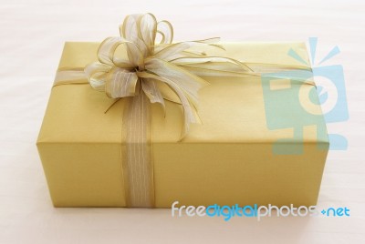 Gift Box With Ribbon Bow On Bed Stock Photo