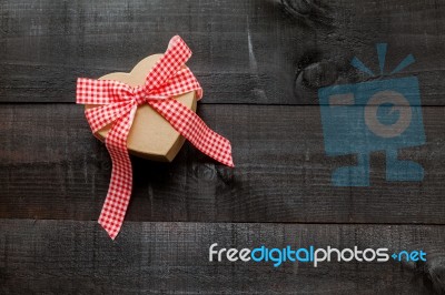 Gift  With A Red And White Bow On Wooden Background Stock Photo