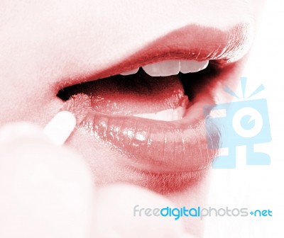 Girl Applying Lip Gloss To Her Lips Stock Photo