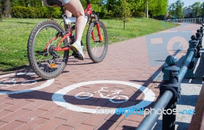 Girl Bicyclist Riding On The Bike Path Stock Photo