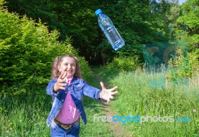 Girl Catching A Plastic Bottle Stock Photo