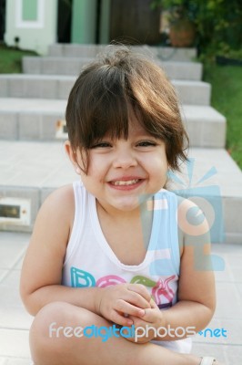 Girl Child Sitting And Smilling Stock Photo