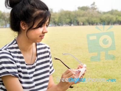 Girl Cleaning Her Glasses Stock Photo