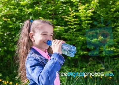 Girl Drinks Water From A Plastic Bottle Stock Photo