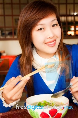 Girl Eating Meatball With Shopstick And Spoon Stock Photo