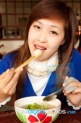 Girl Eating Meatball With Shopstick And Spoon Stock Photo