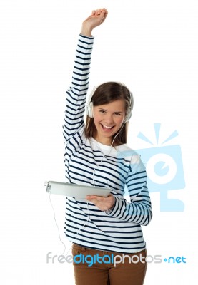 Girl Enjoying Ipad With Raised Arm Stock Photo