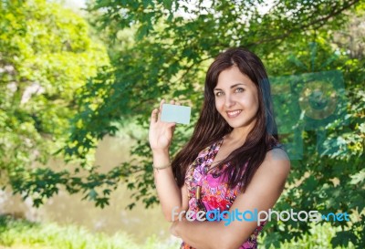 Girl Holding A Credit Card In The Park Stock Photo