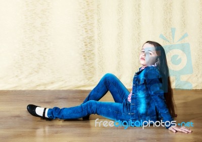 Girl In A Blue Denim Suit Sitting In The Studio Stock Photo