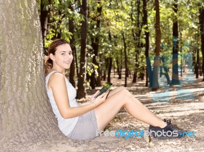 Girl In Park With Tablet Computer Stock Photo