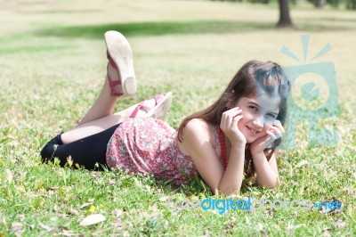 Girl  Laying On Grass Field Stock Photo