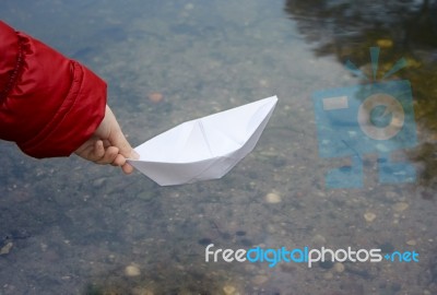 Girl Let A Paper Boat On The River Closeup Stock Photo