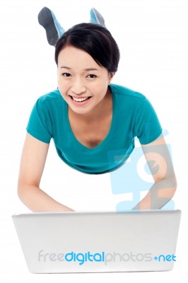 Girl Lying On The Studio Floor And Using Laptop Stock Photo