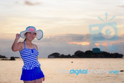 Girl On The Beach At Sunrise Over The Sea Stock Photo